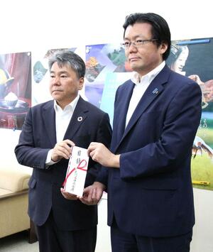 寄付金の目録を手渡す県労働金庫の山崎雅彦理事長(左)と越中隆広・県交通遺児基金執行理事(県総務部長)=10日、県庁