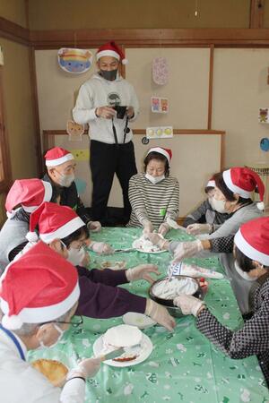 お茶飲み処「うらすだ」のクリスマス会でのケーキ作り。カメラを構えるのが企画した清水義明さん=加茂市後須田