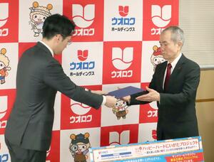 募金活動の実施計画書を県共同募金会の佐藤明会長(右)に手渡すウオロクホールディングスの葛見久賢社長=10日、新潟市中央区