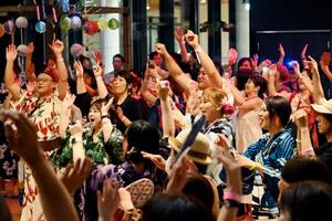 DJのかけ声に合わせてテンポよく手足を動かし、盆踊りを楽しむ参加者たち=6日、仙台市