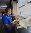 5月3日、メキシコ市のサッカースタジアムで、牛肉のタコスを持つエクトル・レジェスさん。客はここで自分のタコスにタマネギやコリアンダーなどをかけることができる(共同)