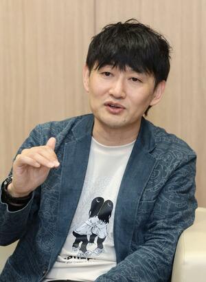 自身の子どもたちが描かれたＴシャツを着て、子育て経験を語る高橋なんぐさん＝新潟市中央区