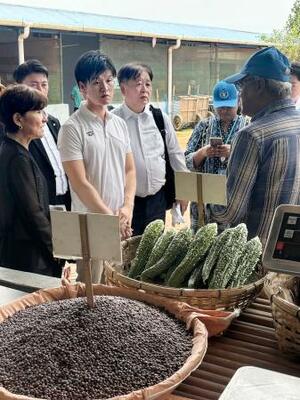 関係者からロヒンギャ難民キャンプの食事情の説明を受ける鈴木農相(手前左から2人目)=30日、バングラデシュ・コックスバザール(共同)