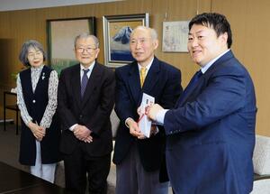 市に寄付金を贈った「水道の塔を愛する会」のメンバーら＝燕市役所
