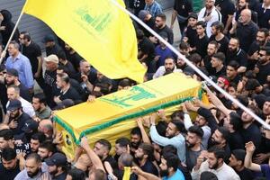 　イスラエル軍の空爆で殺害されたヒズボラ幹部のひつぎを運ぶ参列者＝２４日、レバノン・ベイルート南部（共同）