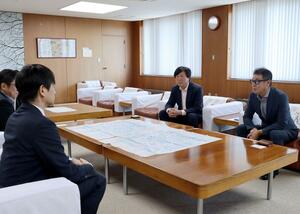 中川幹太市長(左)に観桜会美化活動を報告する実行委メンバー=上越市役所