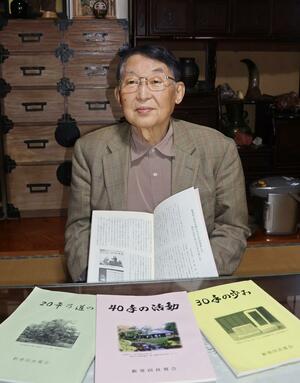 ４０周年の記念誌を手にする星野淳雄さん＝新発田市御幸町３