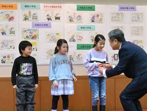 塗り絵に取り組み図書カードを受け取る児童=糸魚川市のヒスイ王国館