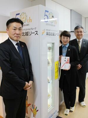 フードロス削減BOXを贈った第四北越リースの高橋伸彰社長(左)=18日、新潟市中央区