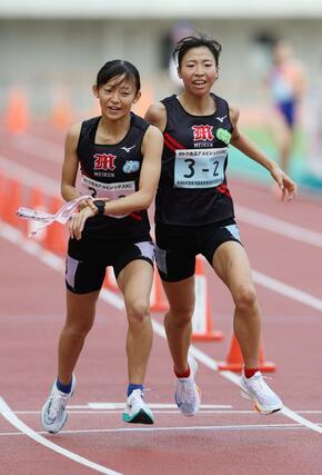 女子 新潟明訓の2区福田せりえ(右)が3区篠澤葉にタスキリレー=新潟市中央区