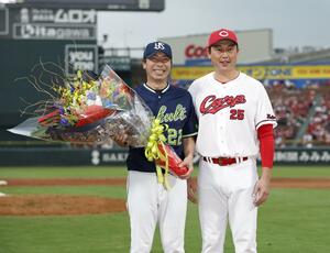 試合後、広島・新井監督（右）から花束を贈られ、笑顔で写真に納まるヤクルト・高津監督＝マツダ