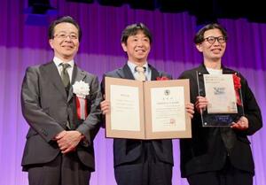 第45回新聞広告大賞を受賞したアサヒビールの古沢毅氏(中央)。左は日本新聞協会の中村史郎会長=16日午後、東京都内