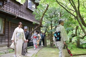 開幕セレモニーで庭園を着物姿で散策する参加者ら＝３０日、新潟市中央区の旧齋藤家別邸