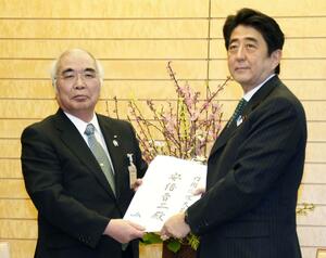 首相の安倍晋三(右)にTPP交渉参加反対の申し入れ書を手渡すJA全中会長の萬歳章=2013年3月、首相官邸