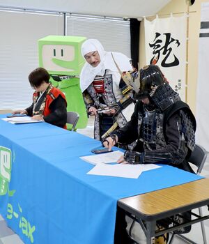 スマートフォンを使った電子申告を模擬体験する越後上越上杉おもてなし武将隊=2月5日、上越市春日山町1