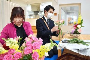 こども園で花を生ける生徒(右)と山本千佳子さん=長岡市蔵王1