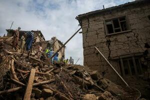 8月31日の地震で壊れた家と救助に当たる人たち=9月2日、アフガニスタン東部クナール州(ロイター=共同)