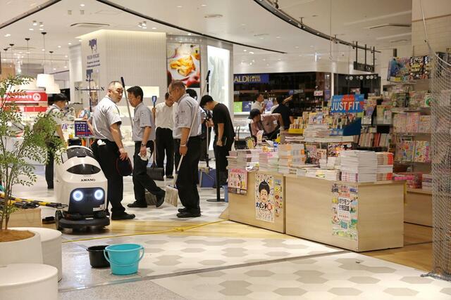 雨漏りでぬれた床を清掃する職員ら=10日、新潟市中央区のくまざわ書店CoCoLo新潟店