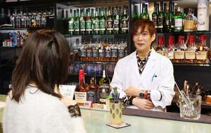 常連客と笑顔で会話する栗山健さん＝新潟市中央区