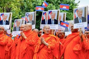 トランプ米大統領の写真を掲げ行進する僧侶=10日、カンボジア・プノンペン(ロイター=共同)