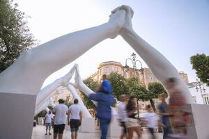 　イタリア南東部のマルティナフランカの広場に展示された「ビルディング・ブリッジズ」。手前のアーチは両手の指が絡まり「愛情」を表現している＝２０２５年６月（撮影・沢田博之、共同）
