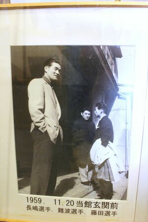 旅館「ごんざや」の玄関前で撮影された長嶋茂雄さん(左)。「1959・11・20」と日付が記されている=佐渡市小木町