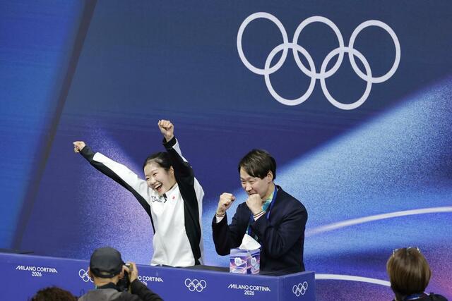 女子ＳＰの得点を確認し、ガッツポーズする中井亜美（左）と中庭健介コーチ＝ミラノ（共同）