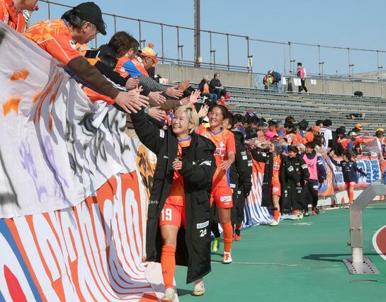 新潟L-ちふれ埼玉 ちふれ埼玉に1-0で勝利し、サポーターと喜びを分かち合う新潟の選手たち=新潟市陸上競技場