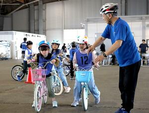 指導を受けながら自転車の乗り方を練習する子どもたち=5月30日、新潟市中央区万代島