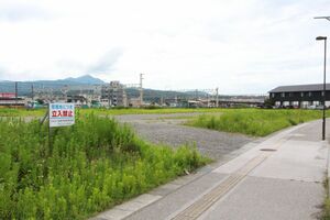 柏崎市が民間宿泊施設の誘致を目指す方針を示した市有地。奥が柏崎駅=8月26日、柏崎市日石町