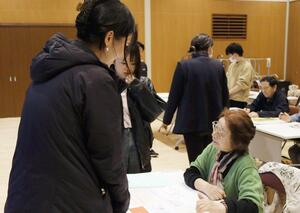 生活習慣などに関する質問を通して新潟水俣病の被害者と談笑する新潟医療福祉大の学生=阿賀野市の安田交流センター