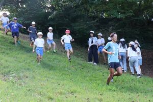 新道小学校の児童と裏山を走るプロトレイルランナーの松永紘明さん=柏崎市の新道小学校