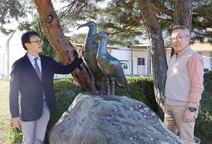 完成したトキの銅像を見つめる制作者の原島秀行さん（右）と猪股快門教頭＝佐渡市新穂正明寺