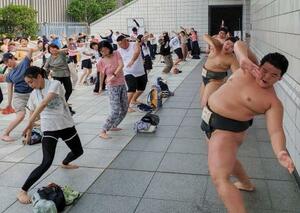 「夏休み!!相撲健康体操」で、力士と体を動かす参加者=6日、東京・両国国技館