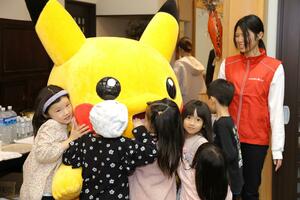 子ども食堂にやってきたピカチュウとふれあう子どもたち=23日、新潟市西区