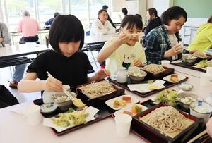 関川村七ケ谷地区のそばや山菜を味わう参加者たち=4月28日、関川村安角