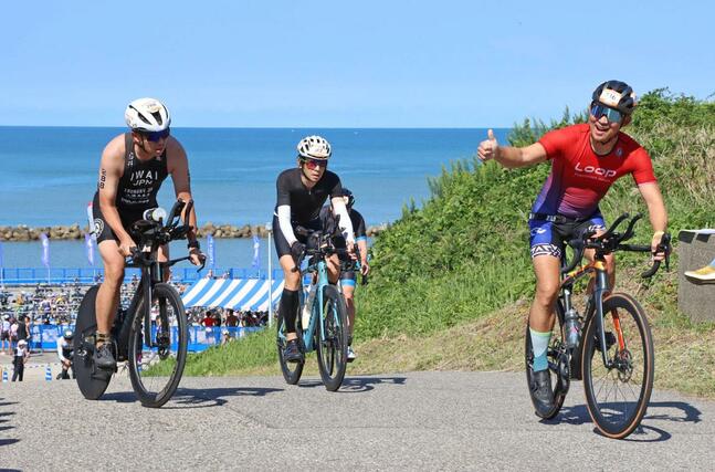 バイクで坂道を駆け抜ける選手たち＝村上市瀬波温泉１
