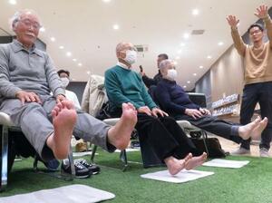 　日産自動車が考案した、車のペダル踏み間違い防止に役立つ体操を体験する高齢者ら＝２４日、神奈川県平塚市