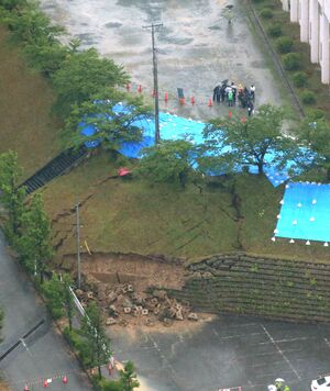 地震発生翌日の山北総合体育館近くの様子。のり面が地震で崩れていた=2019年6月19日、村上市府屋(新潟日報社ヘリから)