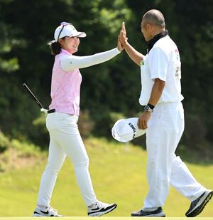 最終9番でバーディーを決めキャディーとハイタッチを交わす高橋彩華=長岡市ヨネックスカントリークラブ
