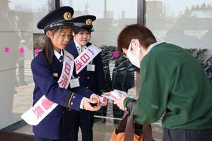 一日消防署長として、来店客に火の用心を呼びかける小学生=小千谷市平沢新田