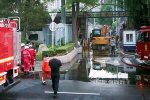 　北京市朝陽区の火災現場付近に集まった消防隊員ら＝２７日（共同）