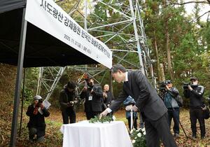 韓国の独自の追悼式後、第四相愛寮跡地で献花する李赫駐日大使ら＝２１日、佐渡市

