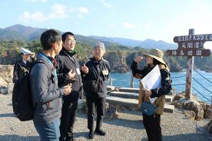 調査員が市職員や地元住民らの案内を受けて改善点や新たな取り組みを確認した現地調査=29日、佐渡市北狄