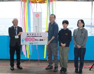 うみがたりの300万人目の入館者となり、笑顔を見せる臼井さん親子=13日、上越市五智