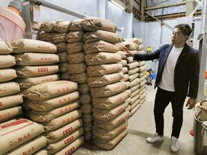 高値で確保したもち米が積まれた渡英商店の倉庫＝田上町