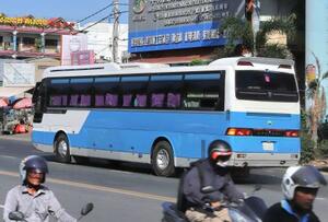 送還する日本人男女29人を乗せたとみられるバス=20日、プノンペン(共同)