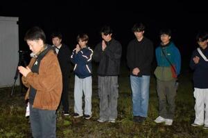 　東海大生が犠牲になったアパート倒壊現場で手を合わせる卒業生の橋村さくらさん（左端）と現役学生ら＝１６日未明、熊本県南阿蘇村