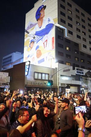 1日、米ロサンゼルス・リトルトーキョーにある大谷翔平選手の壁画の前で、ドジャースのワールドシリーズ連覇を喜ぶファン(共同)