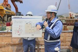 防潮堤の新設工事について説明する北海道電力の担当者=1日、北海道泊村の泊原発敷地内